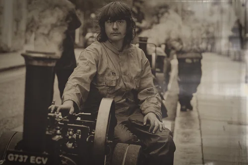 Sepia portrait of a boy driving a miniature traction engine at a Cornish street fair