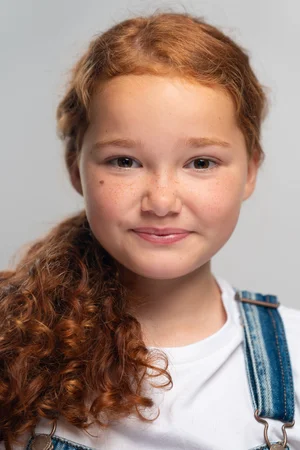 Natural light portrait of a smiling red-haired girl with freckles, Cornwall family photographer