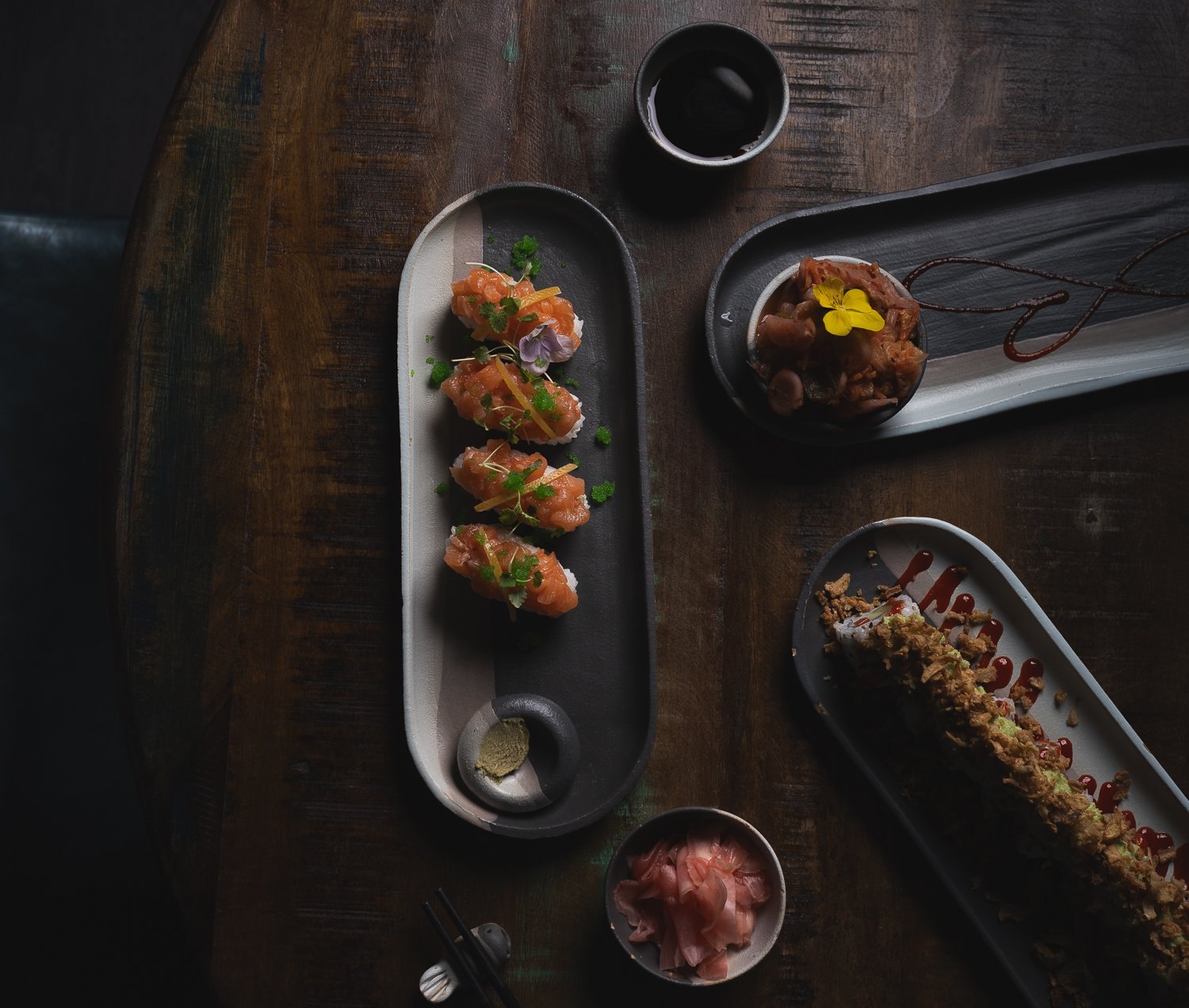 Sushi sharing plates laid out on dark wood, restaurant photography in Cornwall