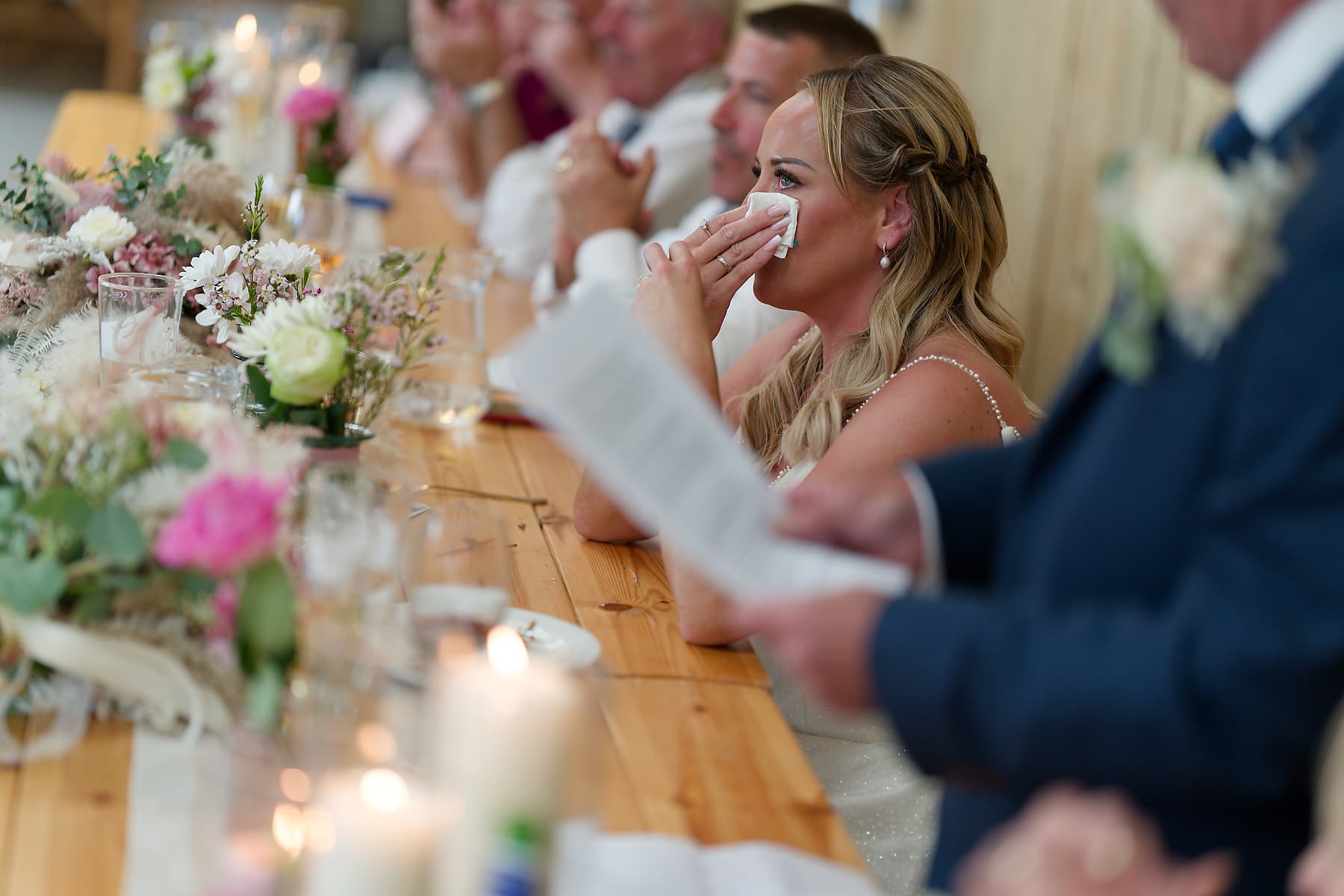 Bride wiping away a tear during the speeches at a Cornwall wedding reception