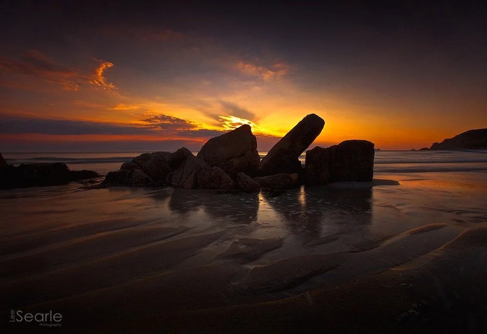 Rusting shipwreck remains on a Cornish beach at sunset, long exposure by Lee Searle