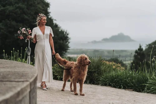 Bride in the gardens with the wedding dog, St Michael's Mount in the distance