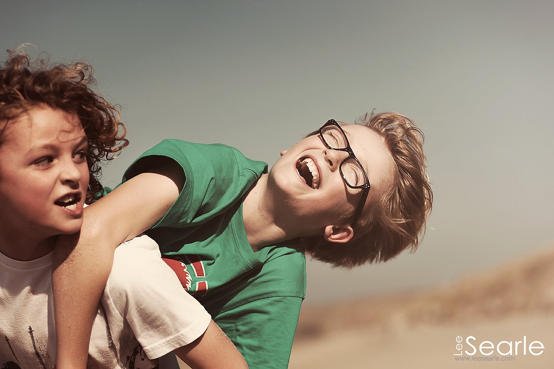 Two brothers messing about and laughing together during a relaxed Cornwall family photo shoot